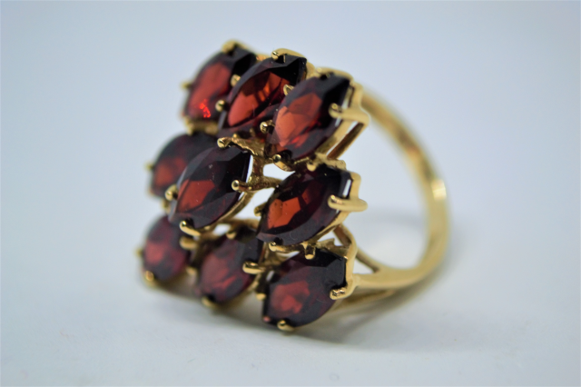 A 9ct Gold With Nine Navette Cut Garnet Ring.