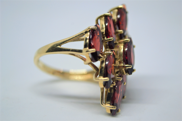 A 9ct Gold With Nine Navette Cut Garnet Ring.