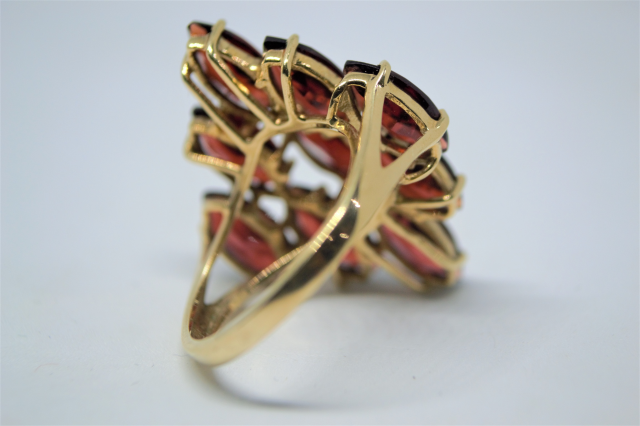 A 9ct Gold With Nine Navette Cut Garnet Ring.