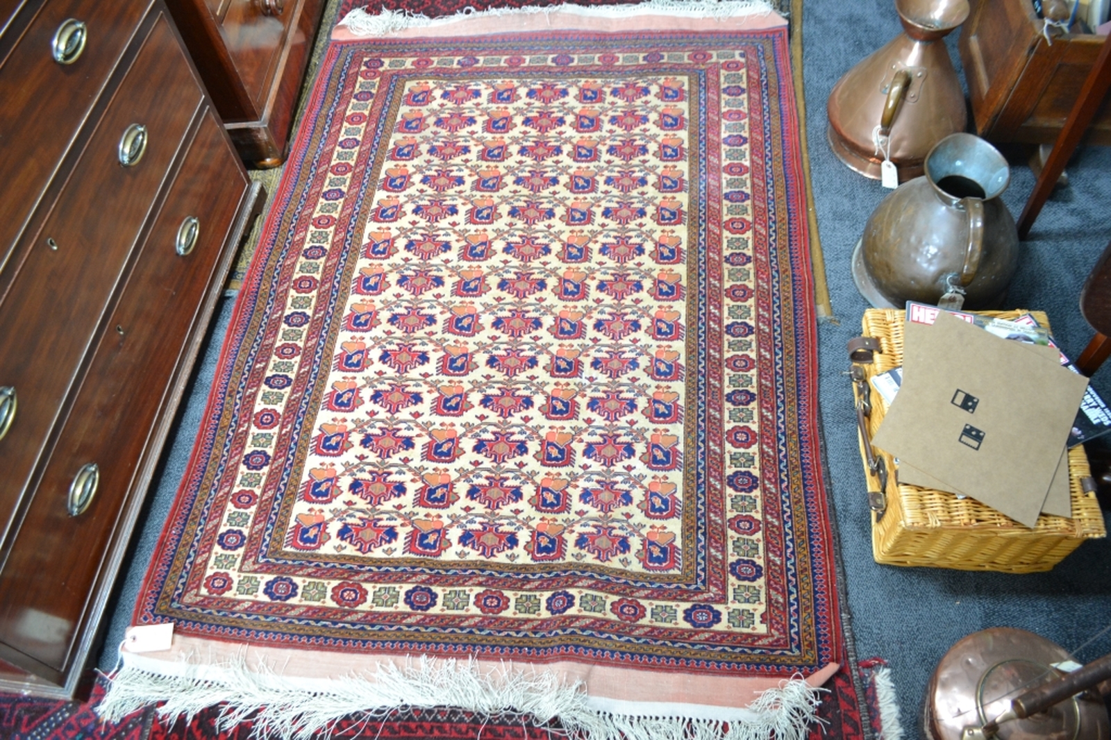 Turkish fringed carpet cream ground with designs in red and blue.