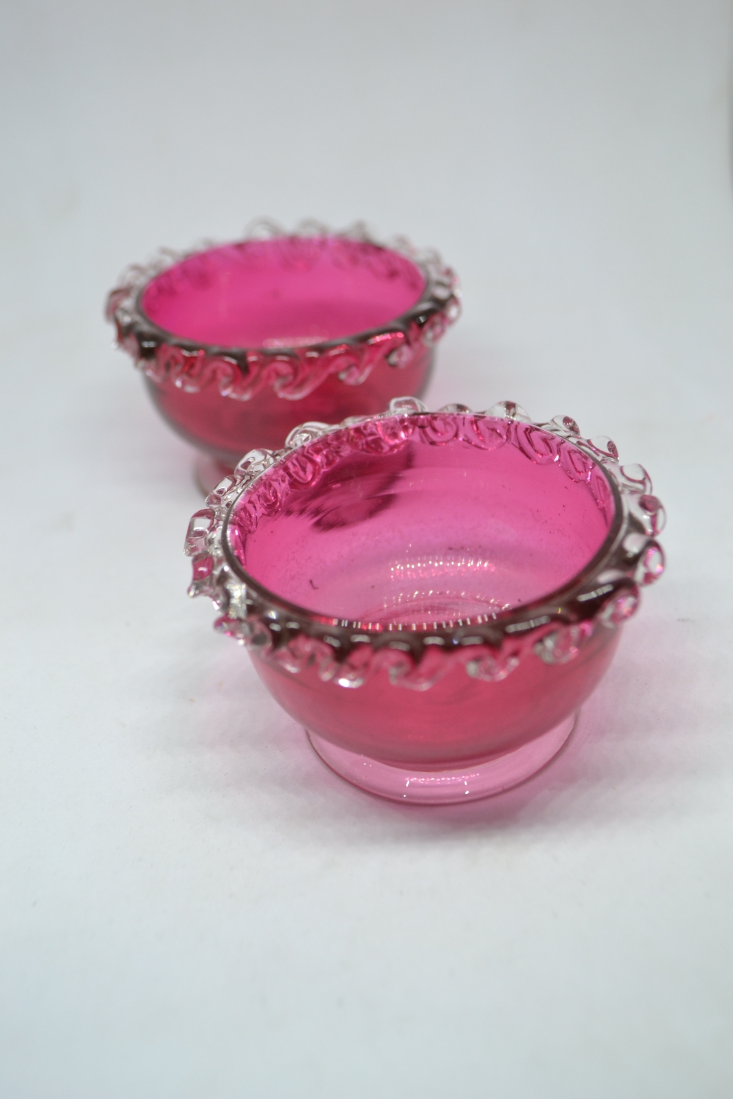 Discover our unique collection of 19th century cranberry salts. Each piece boasts intricate designs and rich color. Shop now for vintage tableware!